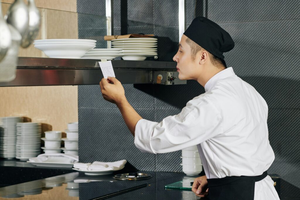 Young cook reading an order